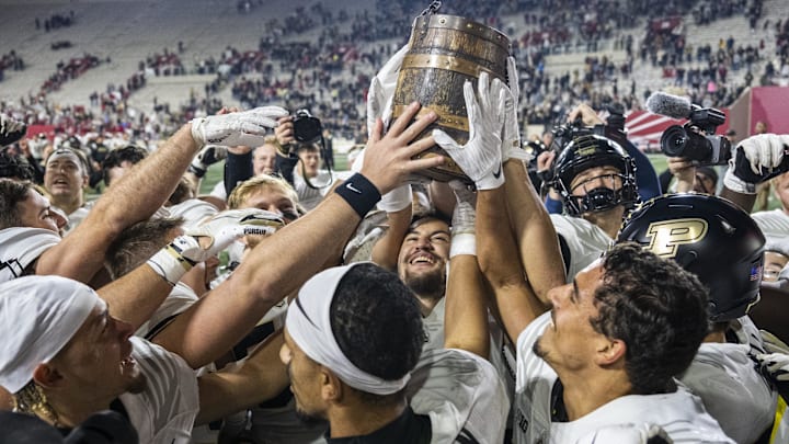 Purdue Boilermakers linebacker Kieren Douglas (43) holds up the Old Oaken Bucket Purdue Boilermakers linebacker Kieren Douglas (43) holds up the Old Oaken Bucket