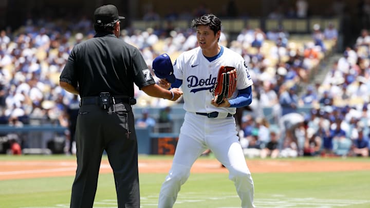 Jun 22, 2025; Los Angeles, California, USA; Los Angeles Dodgers two‑way player Shohei Ohtani (17) gets his glove checked after the first inning against Washington Nationals at Dodger Stadium. Mandatory Credit: Kiyoshi Mio-Imagn Images