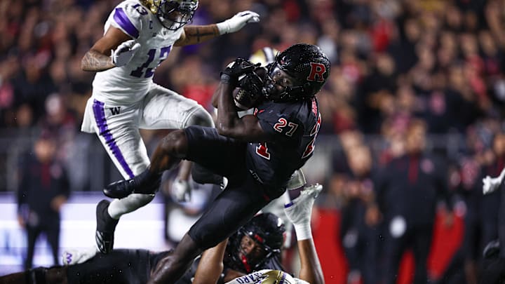 Sep 27, 2024; Piscataway, New Jersey, USA; Rutgers Scarlet Knights running back Samuel Brown V (27) breaks a tackle by Washington Huskies safety Cameron Broussard (8) for a touchdown reception during the second half at SHI Stadium. Mandatory Credit: Vincent Carchietta-Imagn Images