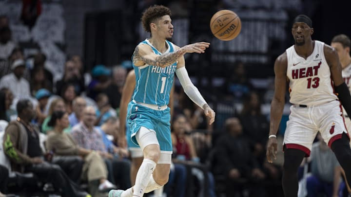 Charlotte Hornets guard LaMelo Ball moves the ball against Miami Heat center Bam Adebayo during the first half at Spectrum Center. Charlotte Hornets guard LaMelo Ball moves the ball against Miami Heat center Bam Adebayo during the first half at Spectrum Center.