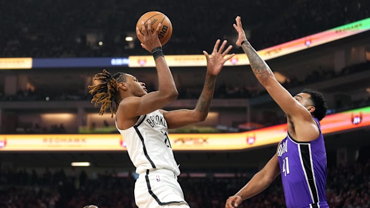 Nov 24, 2024; Sacramento, California, USA; Brooklyn Nets forward Noah Clowney (left) shoots against Sacramento Kings forward Trey Lyles (right) during the first quarter at Golden 1 Center. Mandatory Credit: Darren Yamashita-Imagn Images