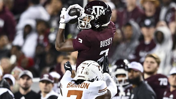 Nov 30, 2024; College Station, Texas, USA; Texas A&M Aggies wide receiver Terry Bussey (2) leaps to catch a pass over Texas Longhorns defensive back Jahdae Barron (7) during the first half. The Longhorns defeated the Aggies 17-7 at Kyle Field. Mandatory Credit: Maria Lysaker-Imagn Images  