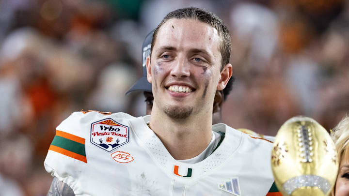 Jan 8, 2026; Glendale, AZ, USA; Miami Hurricanes quarterback Carson Beck (11) celebrates with the trophy after defeating the Mississippi Rebels during the 2026 Fiesta Bowl and semifinal game of the College Football Playoff at State Farm Stadium. Mandatory Credit: Mark J. Rebilas-Imagn Images