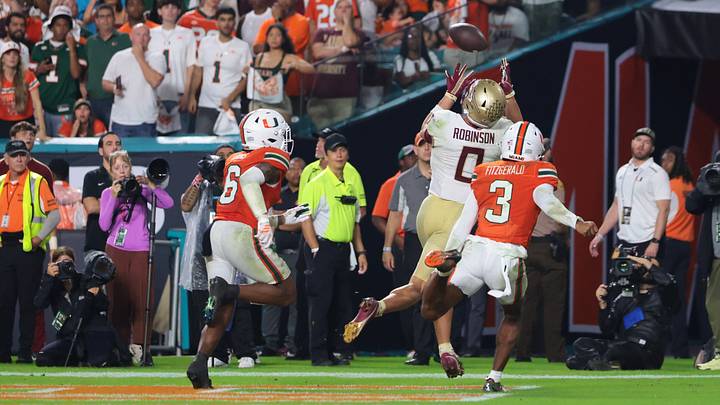 Oct 17, 2026; Miami Gardens, Florida, USA; Florida State Seminoles wide receiver Duce Robinson (0) catches a touchdown during overtime against Miami Hurricanes defensive back Bryce Fitzgerald (3) and defensive back Xavier Lucas (6) at Hard Rock Stadium. Mandatory Credit: Sam Navarro-Imagn Images Oct 17, 2026; Miami Gardens, Florida, USA; Florida State Seminoles wide receiver Duce Robinson (0) catches a touchdown during overtime against Miami Hurricanes defensive back Bryce Fitzgerald (3) and defensive back Xavier Lucas (6) at Hard Rock Stadium. Mandatory Credit: Sam Navarro-Imagn Images