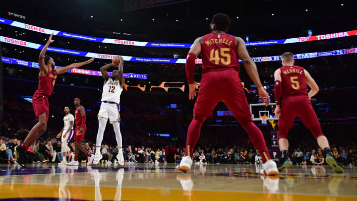 Apr 6, 2024; Los Angeles, California, USA; Los Angeles Lakers forward Taurean Prince (12) shoots against Cleveland Cavaliers forward Evan Mobley (4) during the second half at Crypto.com Arena. Mandatory Credit: Gary A. Vasquez-USA TODAY Sports