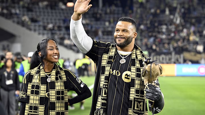 Nov 8, 2024; Los Angeles, California, USA; Los Angeles Rams former player Aaron Donald holds the LAFC falcon as Erica Donald looks on before a 2024 MLS Cup Playoffs Round One match between LAFC and Vancouver Whitecaps FC at BMO Stadium. Mandatory Credit: Alex Gallardo-Imagn Images