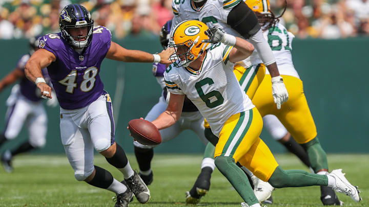 Green Bay Packers quarterback Sean Clifford (6) scrambles away from Baltimore Ravens defensive end Joe Evans (48)