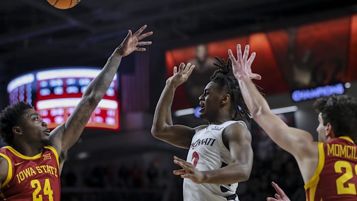 Feb 13, 2024; Cincinnati, Ohio, USA; Cincinnati Bearcats guard Jizzle James (2) passes the ball against Iowa State Cyclones forward Hason Ward (24) and forward Milan Momcilovic (22) in the second half at Fifth Third Arena. Mandatory Credit: Katie Stratman-Imagn Images