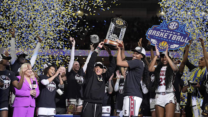 March 9, 2025; Greenville, SC, USA;  South Carolina Gamecocks head coach Dawn Staley hoists the SEC Championship Trophy after her teams win over Texas during the SEC Women’s Tournament at Bon Secours Wellness Arena. Mandatory Credit: Jim Dedmon-Imagn Images