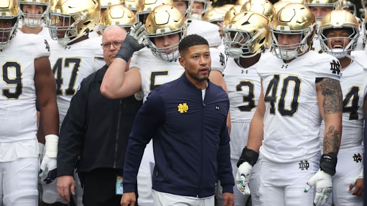 Nov 15, 2025; Pittsburgh, Pennsylvania, USA;  Notre Dame Fighting Irish head coach Marcus Freeman (middle) leads the team onto the field to play the Pittsburgh Panthers at Acrisure Stadium. Mandatory Credit: Charles LeClaire-Imagn Images