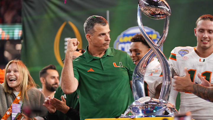 Dec 31, 2025; Arlington, TX, USA; Miami Hurricanes head coach Mario Cristobal lifts the Cotton Bowl trophy after the game against the Ohio State Buckeyes during the 2025 Cotton Bowl and quarterfinal game of the College Football Playoff at AT&T Stadium. Mandatory Credit: Raymond Carlin III-Imagn Images