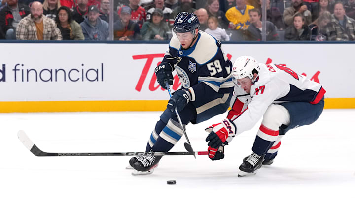 Blue Jackets winger Yegor Chinakhov tries to beat Capitals defenseman Declan Chisholm. 