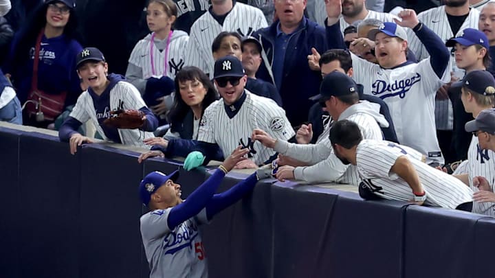 Oct 29, 2024; New York, New York, USA; Los Angeles Dodgers shortstop Mookie Betts (50) makes a catch in foul territory as a New York Yankees fan interferes during the first inning in game four of the 2024 MLB World Series at Yankee Stadium. Mandatory Credit: Brad Penner-Imagn Images Oct 29, 2024; New York, New York, USA; Los Angeles Dodgers shortstop Mookie Betts (50) makes a catch in foul territory as a New York Yankees fan interferes during the first inning in game four of the 2024 MLB World Series at Yankee Stadium. Mandatory Credit: Brad Penner-Imagn Images