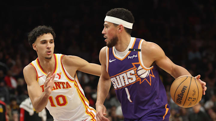 Jan 9, 2025; Phoenix, Arizona, USA; Phoenix Suns guard Devin Booker (1) against Atlanta Hawks forward Zaccharie Risacher (10) in the first half at Footprint Center. Mandatory Credit: Mark J. Rebilas-Imagn Images