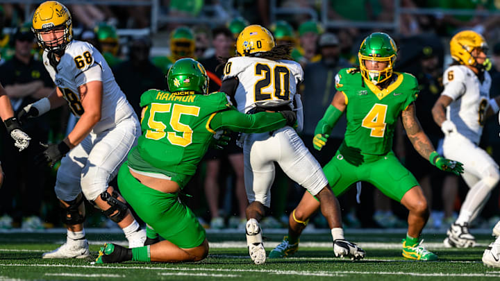 Aug 31, 2024; Eugene, Oregon, USA; Oregon Ducks defensive lineman Derrick Harmon (55) tackles Idaho Vandals running back Elisha Cummings (20) during the third quarter at Autzen Stadium. Mandatory Credit: Craig Strobeck-Imagn Images Aug 31, 2024; Eugene, Oregon, USA; Oregon Ducks defensive lineman Derrick Harmon (55) tackles Idaho Vandals running back Elisha Cummings (20) during the third quarter at Autzen Stadium. Mandatory Credit: Craig Strobeck-Imagn Images