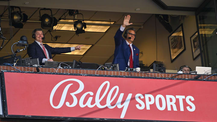 Mar 30, 2023; St. Louis, Missouri, USA;  Bally Sports Midwest announcer Chip Caray and Brad Thompson wave to the fans during the second inning of an opening day game between the St. Louis Cardinals and the Toronto Blue Jays at Busch Stadium. Mandatory Credit: Jeff Curry-Imagn Images