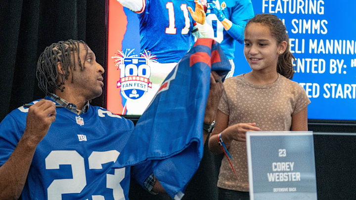 Arianna Villarreal, 10, of Clifton, gets an autograph from Corey Webster, former NY Giants defensive back, during the Giants Fan Fest, celebrating 100 seasons, at MetLife Stadium on Friday, Sept. 6, 2024.