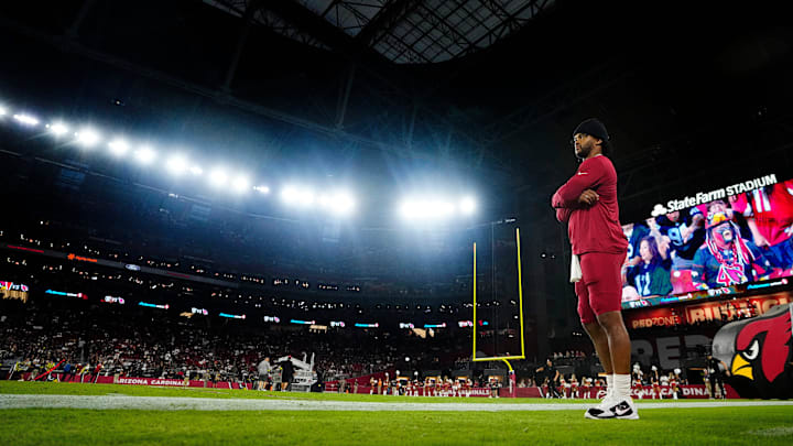 Cardinals quarterback Kyler Murray gets wired up on the sidelines during a preseason game against the Raiders at State Farm Stadium in Glendale on Aug. 23, 2025.