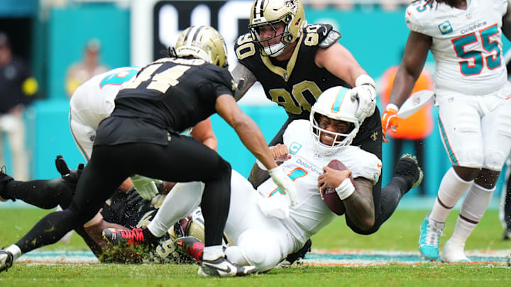Miami Dolphins quarterback Tua Tagovailoa (1) gets tackled by New Orleans Saints defensive tackle Bryan Bresee (90) during the second half at Hard Rock Stadium. 