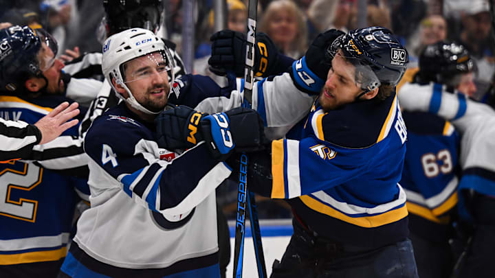 May 2, 2025; St. Louis, Missouri, USA; Winnipeg Jets defenseman Neal Pionk (4) and St. Louis Blues defenseman Philip Broberg (6) get physical during the third period in game six of the first round of the 2025 Stanley Cup Playoffs at Enterprise Center. Mandatory Credit: Connor Hamilton-Imagn Images