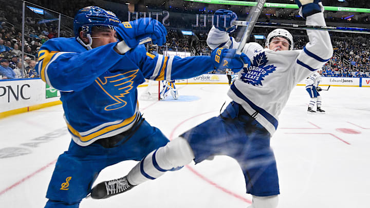 Mar 28, 2026; St. Louis, Missouri, USA; Toronto Maple Leafs right wing Easton Cowan (53) checks St. Louis Blues defenseman Logan Mailloux (23) during the first period at Enterprise Center. Mandatory Credit: Jeff Curry-Imagn Images