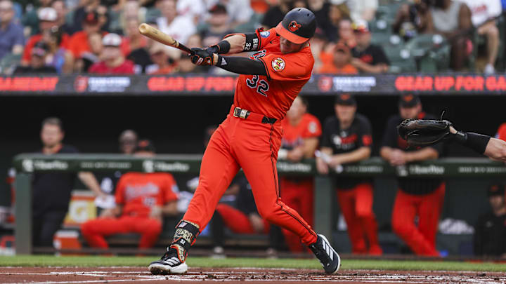 Jul 26, 2025; Baltimore, Maryland, USA;  Baltimore Orioles’ first baseman Ryan O'Hearn (32) hits a ground ball to left side of the field for an RBI against the Colorado Rockies in first inning at Oriole Park at Camden Yards