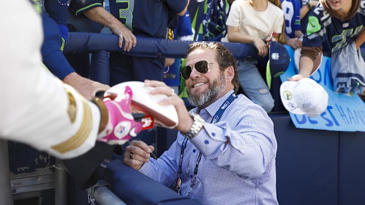Oct 6, 2024; Seattle, Washington, USA; Seattle Seahawks general manager John Schneider signs sutographs during pregame warmups against the New York Giants at Lumen Field. Mandatory Credit: Joe Nicholson-Imagn Images