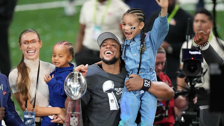 Feb 9, 2025; New Orleans, LA, USA; Philadelphia Eagles running back Saquon Barkley celebrates with fiancée Anna Congdon, son Saquon Barkley Jr., 2, and daughter Jada Barkley 6, after the Philadelphia Eagles 40-22 victory over the Kansas City Chiefs in Super Bowl LIX at the Caesars Superdome.