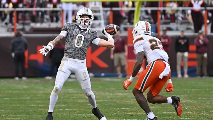 Nov 22, 2025; Blacksburg, Virginia, USA; Virginia Tech Hokies wide receiver Ayden Greene (0) throws a pass as Miami (FL) Hurricanes defensive back Dylan Day (23) pursues during the fourth quarter at Lane Stadium. Mandatory Credit: Brian Bishop-Imagn Images Nov 22, 2025; Blacksburg, Virginia, USA; Virginia Tech Hokies wide receiver Ayden Greene (0) throws a pass as Miami (FL) Hurricanes defensive back Dylan Day (23) pursues during the fourth quarter at Lane Stadium. Mandatory Credit: Brian Bishop-Imagn Images