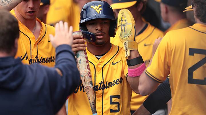 West Virginia Mountaineers junior Armani Guzman (5) is celebrated after scoring a run against Kansas Jayhawks during the game inside Hoglund Ballpark on May 10, 2026.