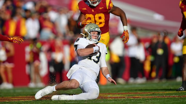 Notre Dame Fighting Irish quarterback Riley Leonard (13) moves the ball against the Southern California Trojans during the second half at the Los Angeles Memorial Coliseum.