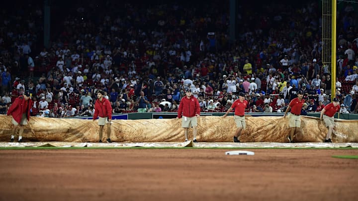 Jul 1, 2025; Boston, Massachusetts, USA;  Boston Red Sox grounds crew pulls the tarp on the field during a rain delay in the third inning against the Cincinnati Reds at Fenway Park. Mandatory Credit: Bob DeChiara-Imagn Images