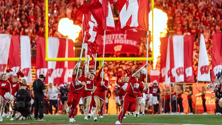 Wisconsin Badgers cheerleaders lead the football team out of the tunnel. Wisconsin Badgers cheerleaders lead the football team out of the tunnel.