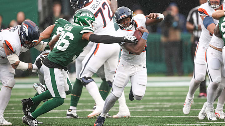 Sep 29, 2024; East Rutherford, New Jersey, USA; Denver Broncos running back Javonte Williams (33) carries the ball as New York Jets safety Chuck Clark (36) tackles defends during the second half at MetLife Stadium. 