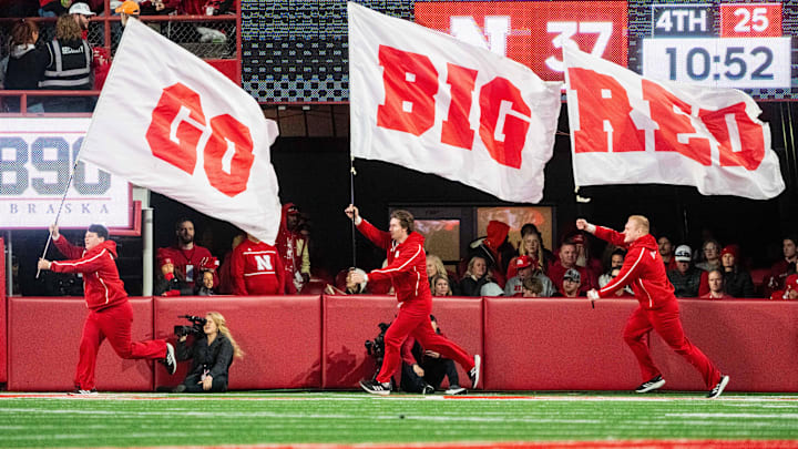 Nebraska Cornhuskers cheerleaders carry flags across the field after a score against the Wisconsin Badgers during the fourth quarter at Memorial Stadium.