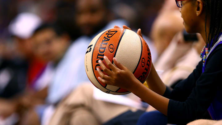 Sep 7, 2014; Phoenix, AZ, USA; A young female fan holds an official Spalding WNBA basketball during the game between the Phoenix Mercury against the Chicago Sky during game one of the WNBA Finals at US Airways Center. The Mercury defeated the Sky 83-62. Mandatory Credit: Mark J. Rebilas-Imagn Images
