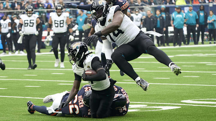Oct 13, 2024; London, United Kingdom; Jacksonville Jaguars wide receiver Brian Thomas Jr. (7) carries the ball protected by offensive tackle Cam Robinson (74) during the first half of an NFL International Series game against the Chicago Bears at Tottenham Hotspur Stadium. Mandatory Credit: Peter van den Berg-Imagn Images