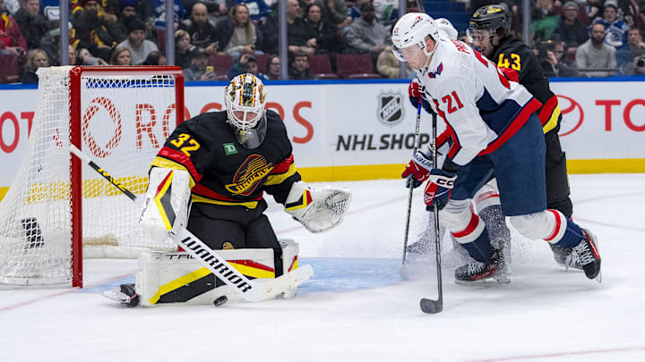 Jan 25, 2025; Vancouver, British Columbia, CAN; Washington Capitals forward Aliaksei Protas (21) and Vancouver Canucks defenseman Quinn Hughes (43) watch goalie Kevin Lankinen (32) make a save in the third period at Rogers Arena. Mandatory Credit: Bob Frid-Imagn Images