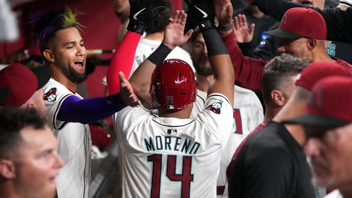 Arizona Diamondbacks teammates high-five Gabriel Moreno (14) in the dugout after he scored a run against the Colorado Rockies on Opening Day at Chase Field. Arizona Diamondbacks teammates high-five Gabriel Moreno (14) in the dugout after he scored a run against the Colorado Rockies on Opening Day at Chase Field.