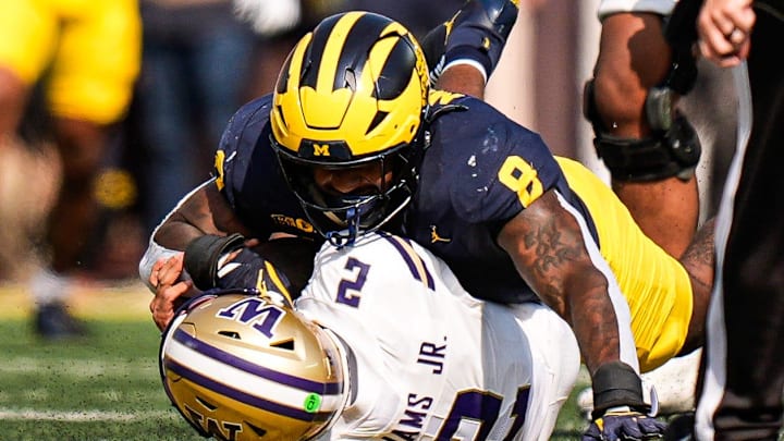 Michigan edge Derrick Moore (8) sacks Washington quarterback Demond Williams Jr. (2) during the first half at Michigan Stadium in Ann Arbor on Saturday, Oct. 18, 2025.