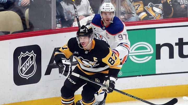 Jan 9, 2025; Pittsburgh, Pennsylvania, USA;  Pittsburgh Penguins center Sidney Crosby (87) and Edmonton Oilers center Connor McDavid (97) chase the puck during the third period at PPG Paints Arena. Mandatory Credit: Charles LeClaire-Imagn Images