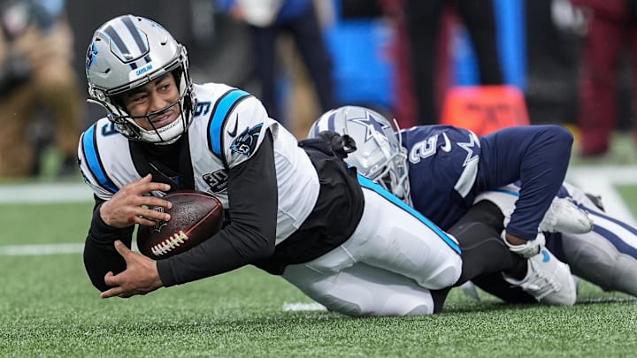 Dec 15, 2024; Charlotte, North Carolina, USA; Carolina Panthers quarterback Bryce Young (9) is sacked by Dallas Cowboys cornerback Jourdan Lewis (2) during the second half at Bank of America Stadium. Mandatory Credit: Jim Dedmon-Imagn Images