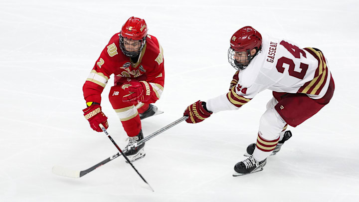 Apr 13, 2024; Saint Paul, Minnesota, USA; Denver Pioneers defenseman Sean Behrens (2) and Boston College Eagles forward Andre Gasseau (24) compete for the puck during the second period of the championship game of the 2024 Frozen Four college ice hockey tournament at Xcel Energy Center. Mandatory Credit: Matt Krohn-Imagn Images