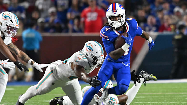 Buffalo Bills' running back James Cook (4) runs against Miami Dolphins' linebacker Jordyn Brooks (20).