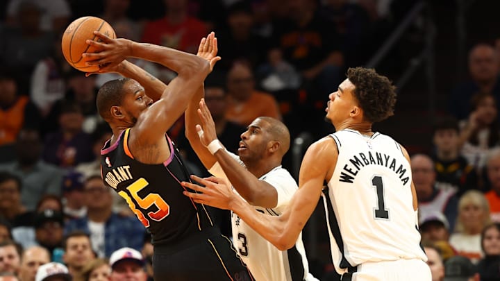 Dec 3, 2024; Phoenix, Arizona, USA; Phoenix Suns forward Kevin Durant (35) against San Antonio Spurs guard Chris Paul (3) and center Victor Wembanyama (1) in the first half of an NBA Cup game at Footprint Center. Mandatory Credit: Mark J. Rebilas-Imagn Images