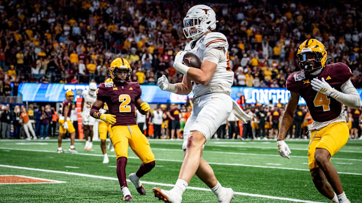 Texas Longhorns tight end Gunnar Helm (85) catches a pass to score a touchdown, evading defense from Arizona State Sun Devils defensive back Myles Rowser (4), during the second overtime period as the Texas Longhorns play the Arizona State Sun Devils in the Peach Bowl College Football Playoff quarterfinal at Mercedes-Benz Stadium in Atlanta, Georgia, Jan. 1, 2025.
