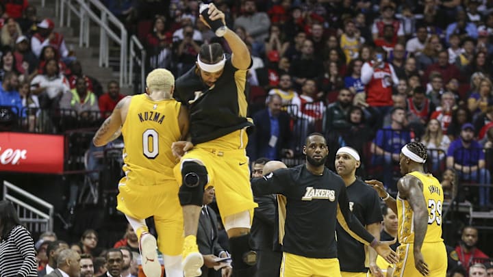 Jan 18, 2020; Houston, Texas, USA; Los Angeles Lakers forward LeBron James (23) looks on as forward Kyle Kuzma (0) and center JaVale McGee (7) celebrate after a play during the fourth quarter against the Houston Rockets at Toyota Center. Mandatory Credit: Troy Taormina-Imagn Images