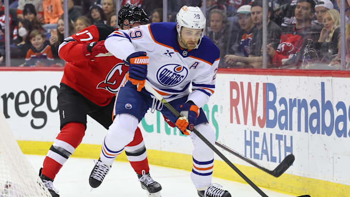 Mar 13, 2025; Newark, New Jersey, USA; Edmonton Oilers center Leon Draisaitl (29) skates with the puck as New Jersey Devils defenseman Simon Nemec (17) defends during the first period at Prudential Center. Mandatory Credit: Ed Mulholland-Imagn Images