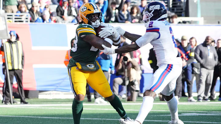 Nov 16, 2025; East Rutherford, New Jersey, USA; Green Bay Packers running back Emanuel Wilson (23) scores a touchdown against New York Giants cornerback Deonte Banks (2) during the second quarter at MetLife Stadium. Mandatory Credit: Robert Deutsch-Imagn Images