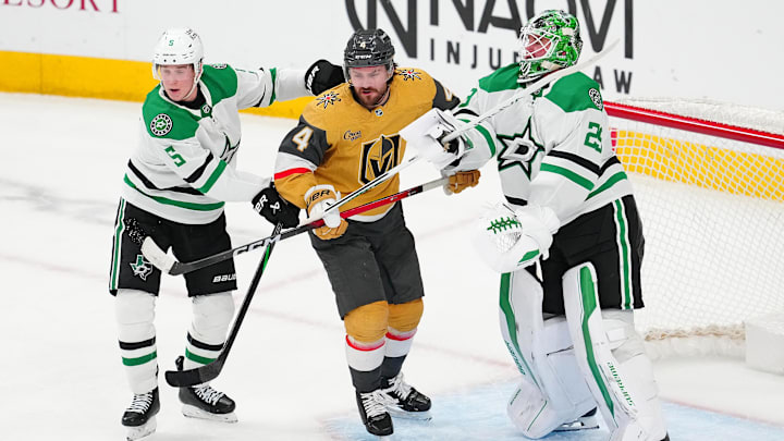 Jan 29, 2026; Las Vegas, Nevada, USA; Vegas Golden Knights defenseman Rasmus Andersson (4) is checked by Dallas Stars defenseman Nils Lundkvist (5) and goaltender Jake Oettinger (29) during the third period at T-Mobile Arena. Mandatory Credit: Stephen R. Sylvanie-Imagn Images